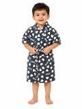 A young child wearing a dark gray plush bathrobe with a white heart and 'LOVE' print, standing against a solid white background.