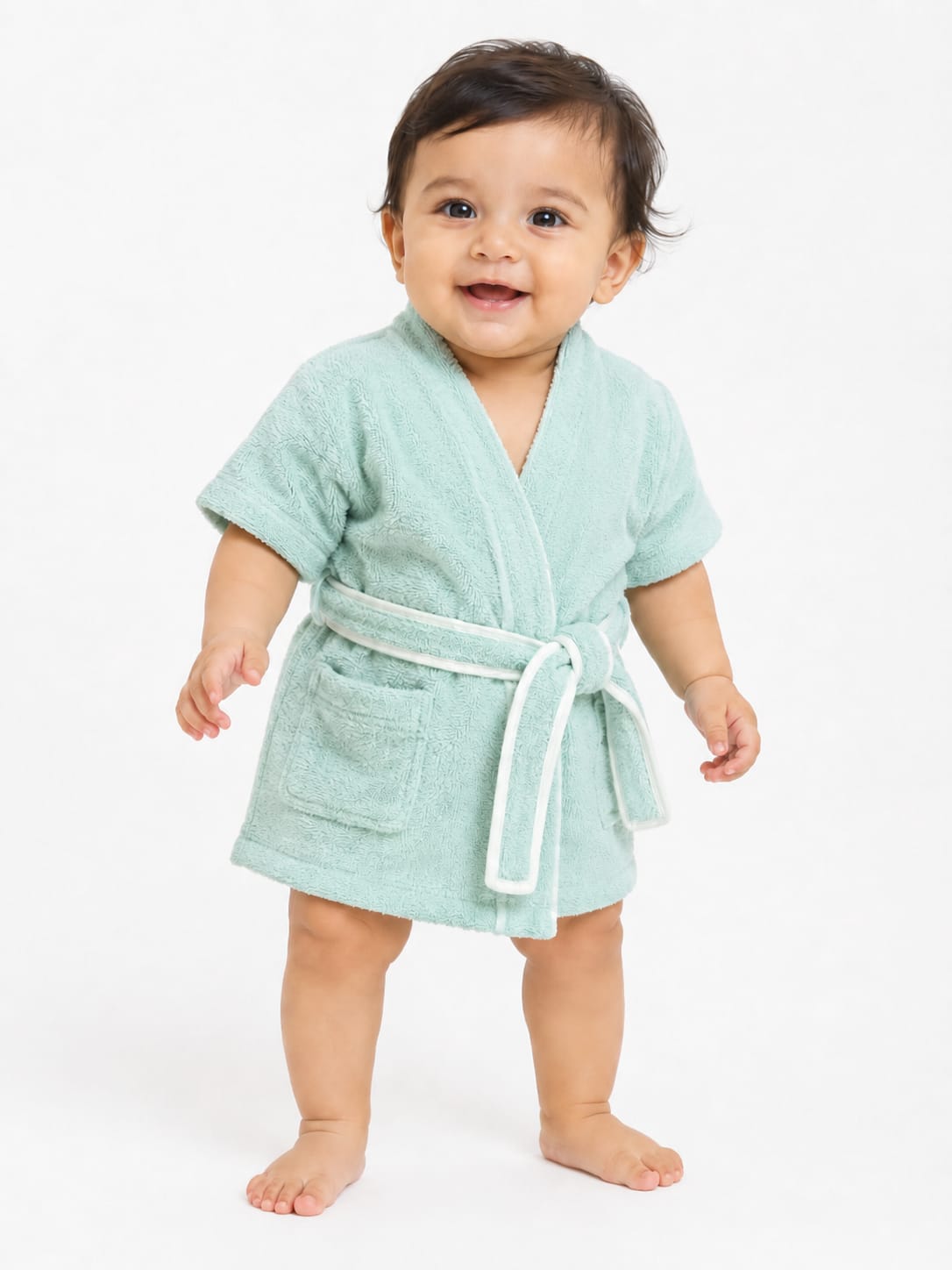 A baby standing against a white background, shown from both the front and back wearing a short-sleeve bathrobe in a pale mint green color with a white belt trim.