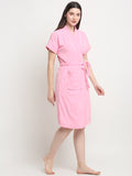 A Woman wearing a baby pink micro terry bathrobe with a tie belt