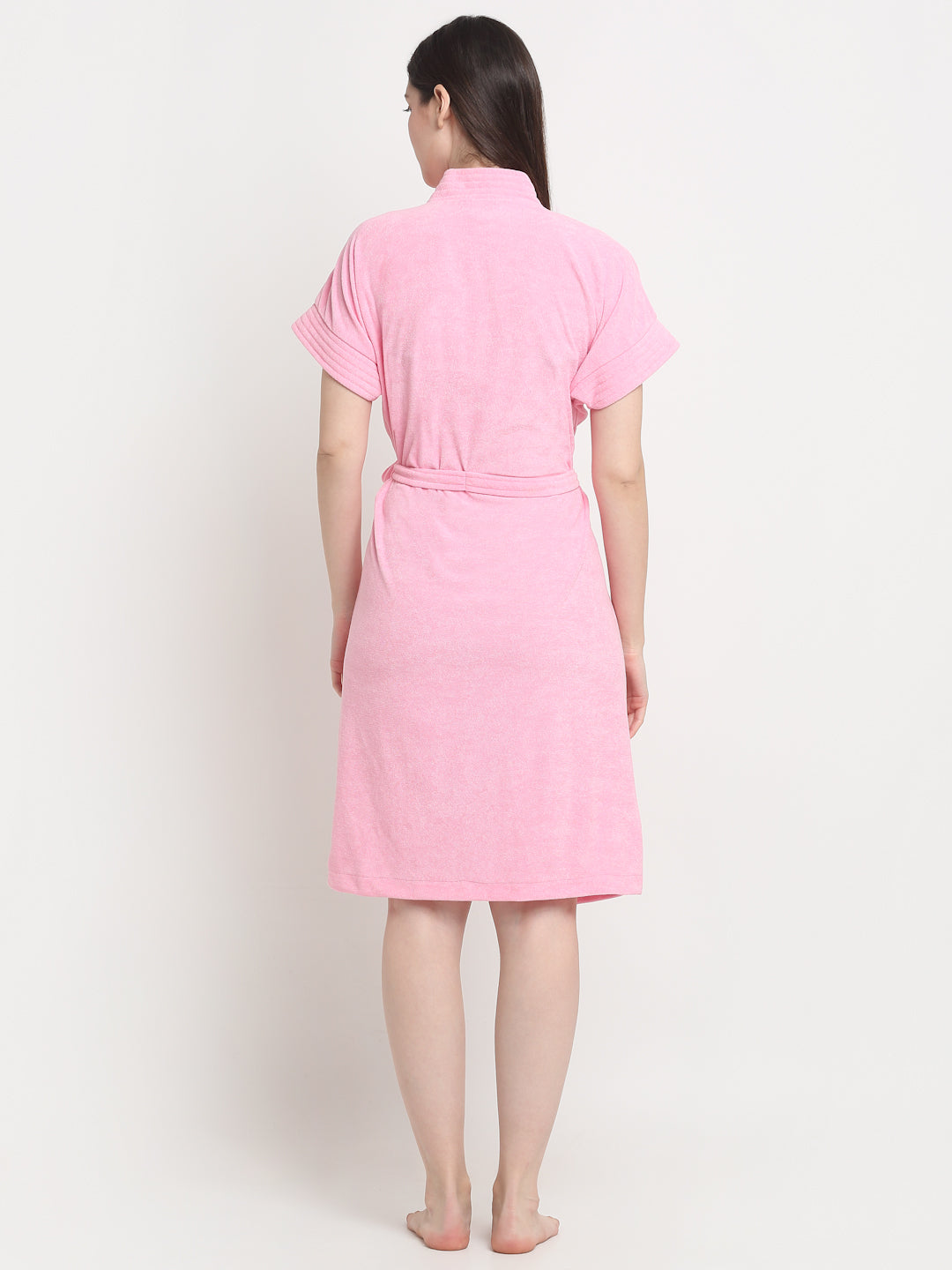 Back view of a woman wearing a baby pink micro terry bathrobe with a tie belt