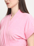 Close-up of a woman wearing a baby pink micro terry bathrobe with a tie belt