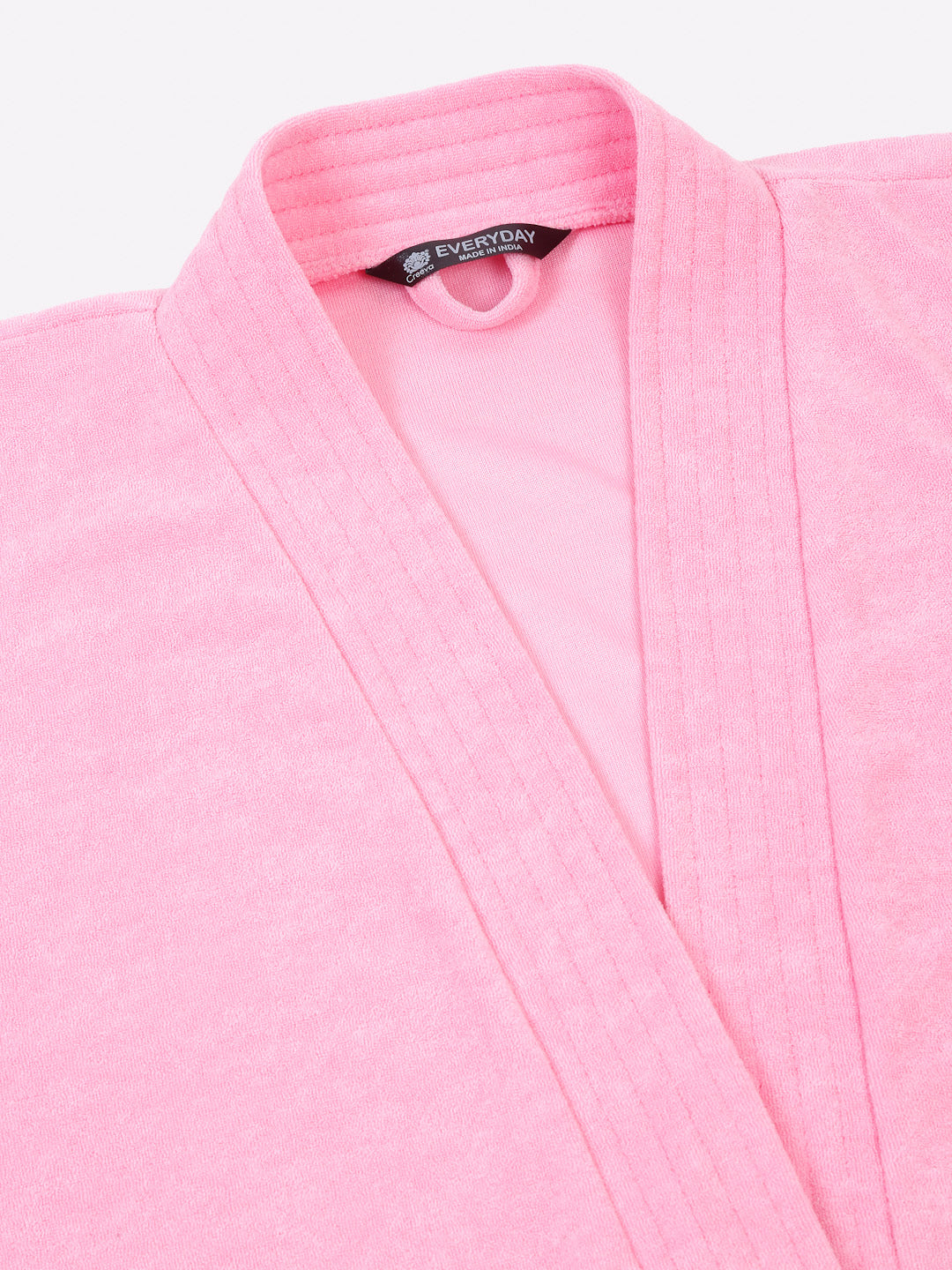 Close-up of a baby pink micro terry bathrobe showing the collar and fabric texture
