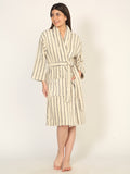 Woman wearing a striped bathrobe on a plain background