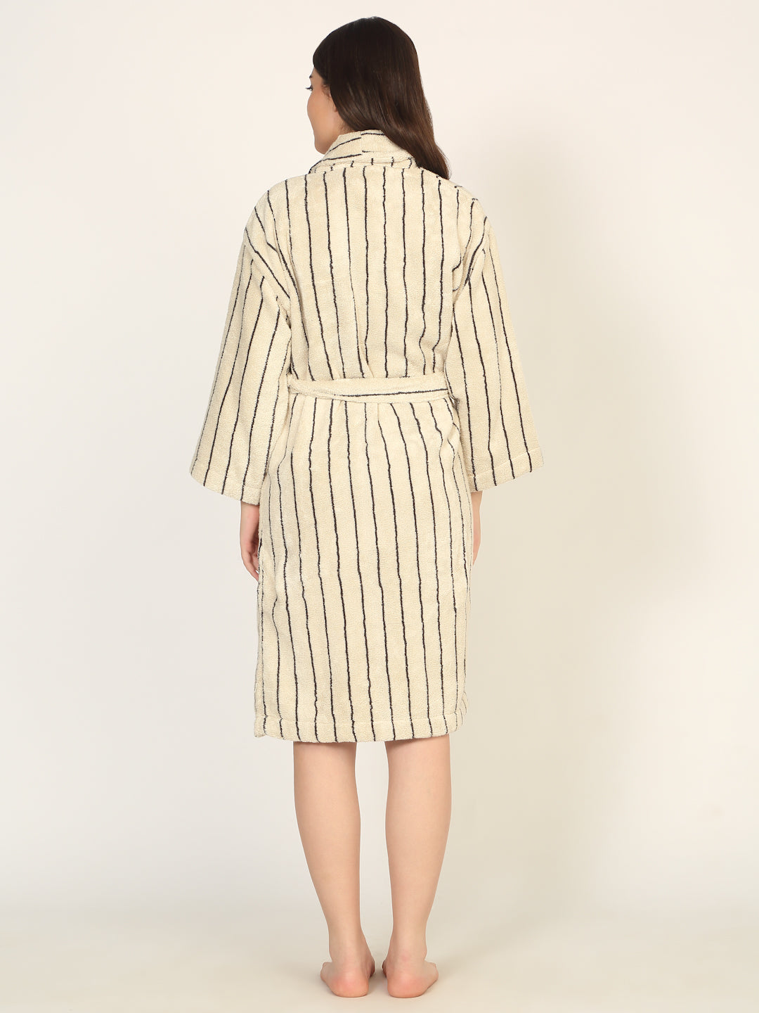 Woman wearing a striped dress with a belt on a white background