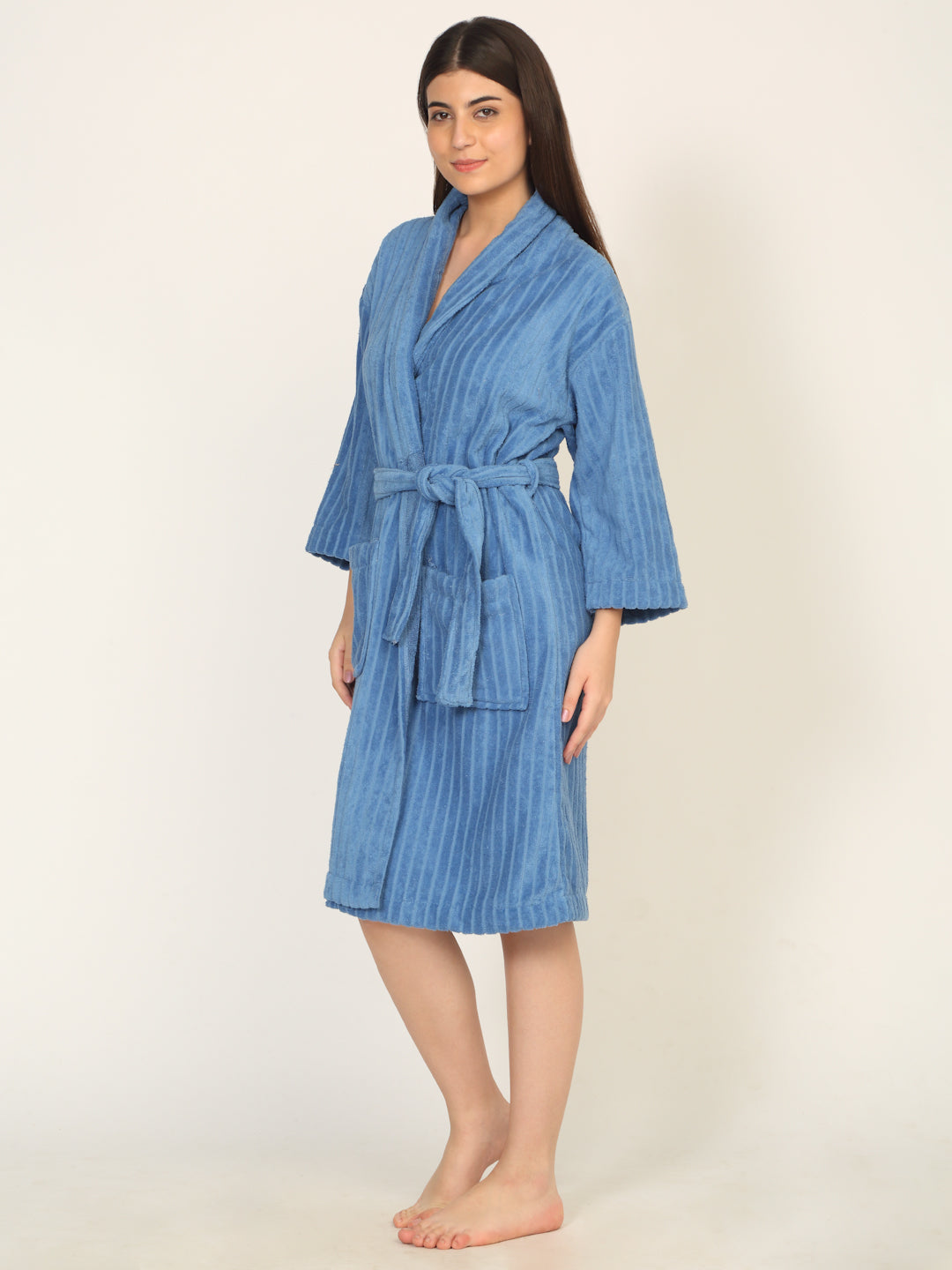 Woman wearing a blue striped robe on a beige background