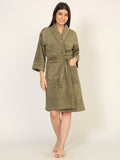 Woman wearing a green bathrobe on a white background