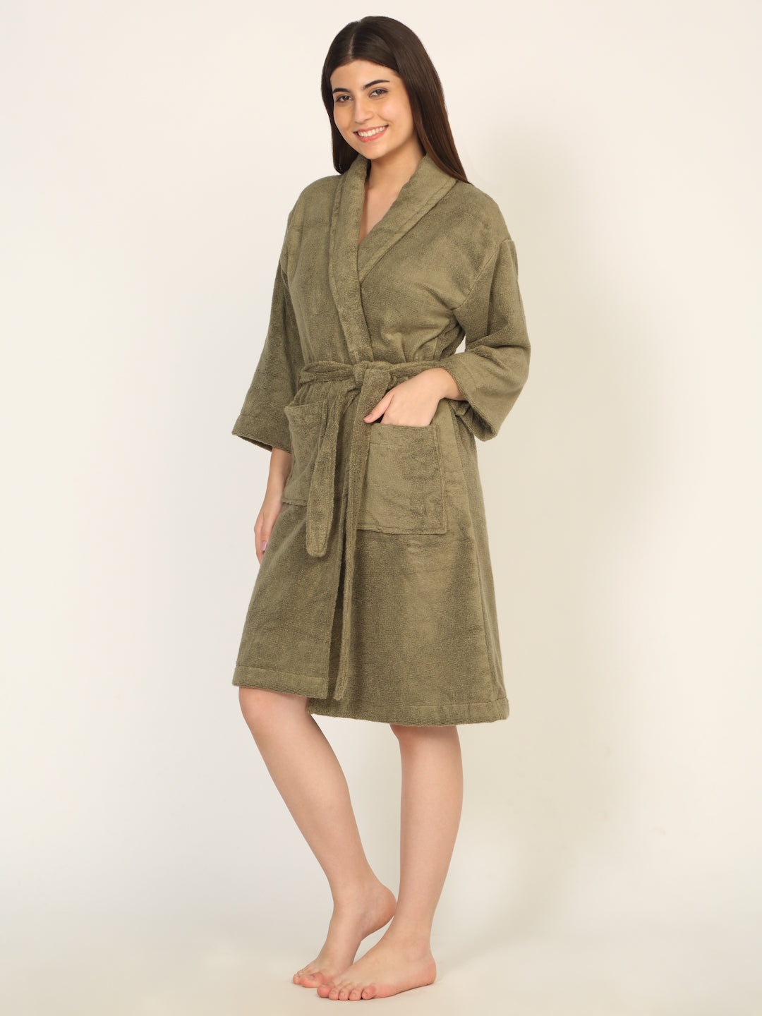 Woman wearing a green robe against a plain background