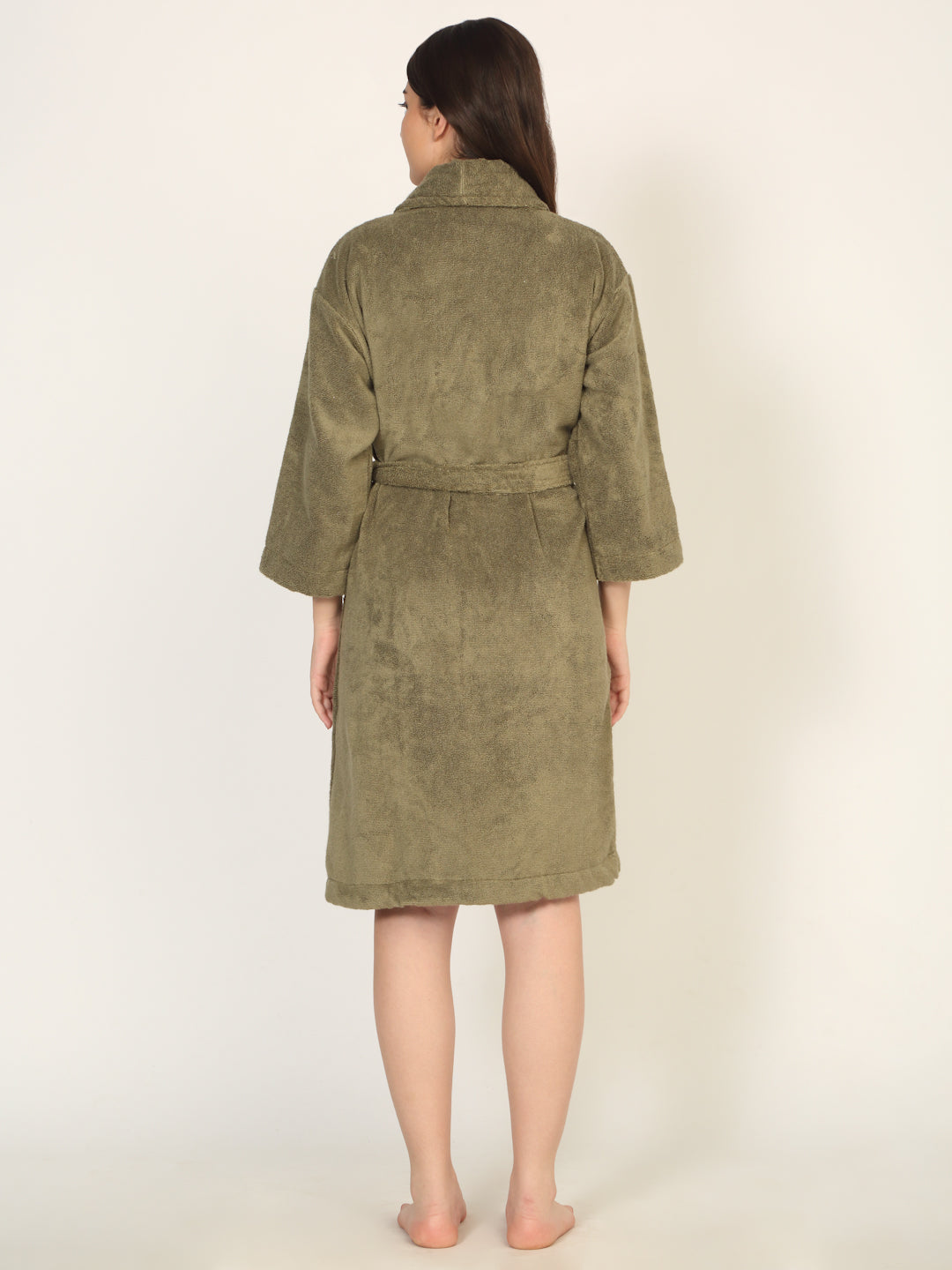 Woman wearing a green robe against a white background