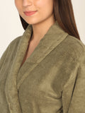 Close-up of a person wearing a green robe against a neutral background