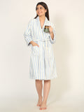 Woman wearing a striped robe holding a mug on a plain background