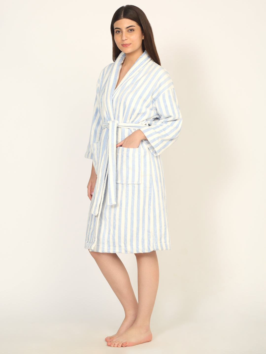 Woman wearing a striped robe on a plain background