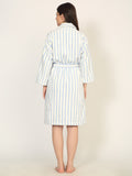 Woman wearing a striped robe on a plain background