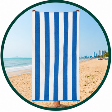 Blue and white striped towel on a beach with ocean and skyline in the background