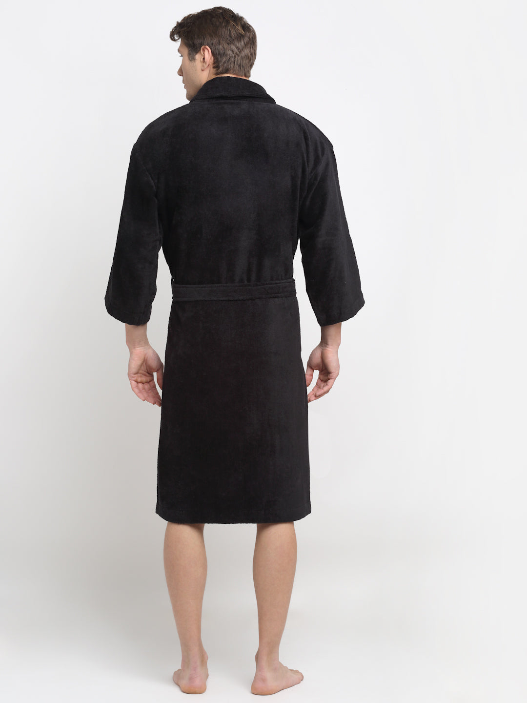 Back view of a man wearing a black cotton bathrobe with a tie belt