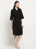 Woman wearing a black micro terry bathrobe with a tie belt