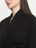 Close-up of a woman wearing a black micro terry bathrobe with a tie belt