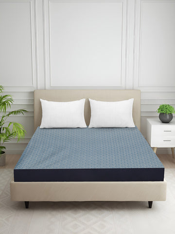 Blue patterned mattress protector on a double bed