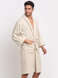 A man wearing a cream-colored textured bathrobe with vertical stripes, standing against a plain light gray background.