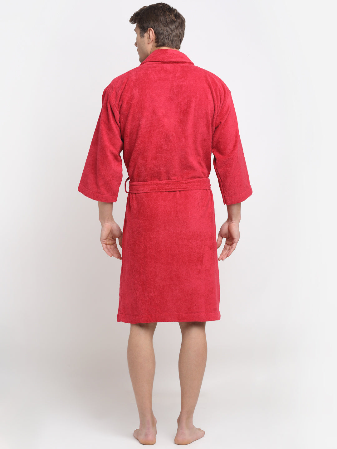 Back view of a woman wearing a crimson cotton bathrobe with a tie belt