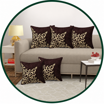 Decorative pillows with gold patterns on a gray sofa in a living room setting.