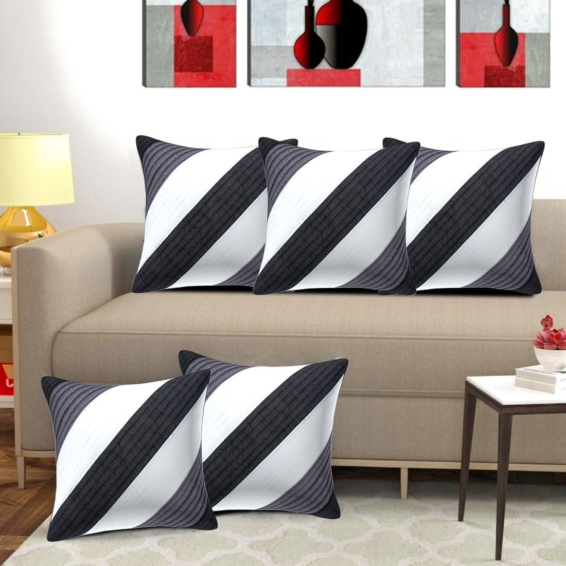 Decorative pillows with black and white striped pattern on a beige sofa in a living room setting.