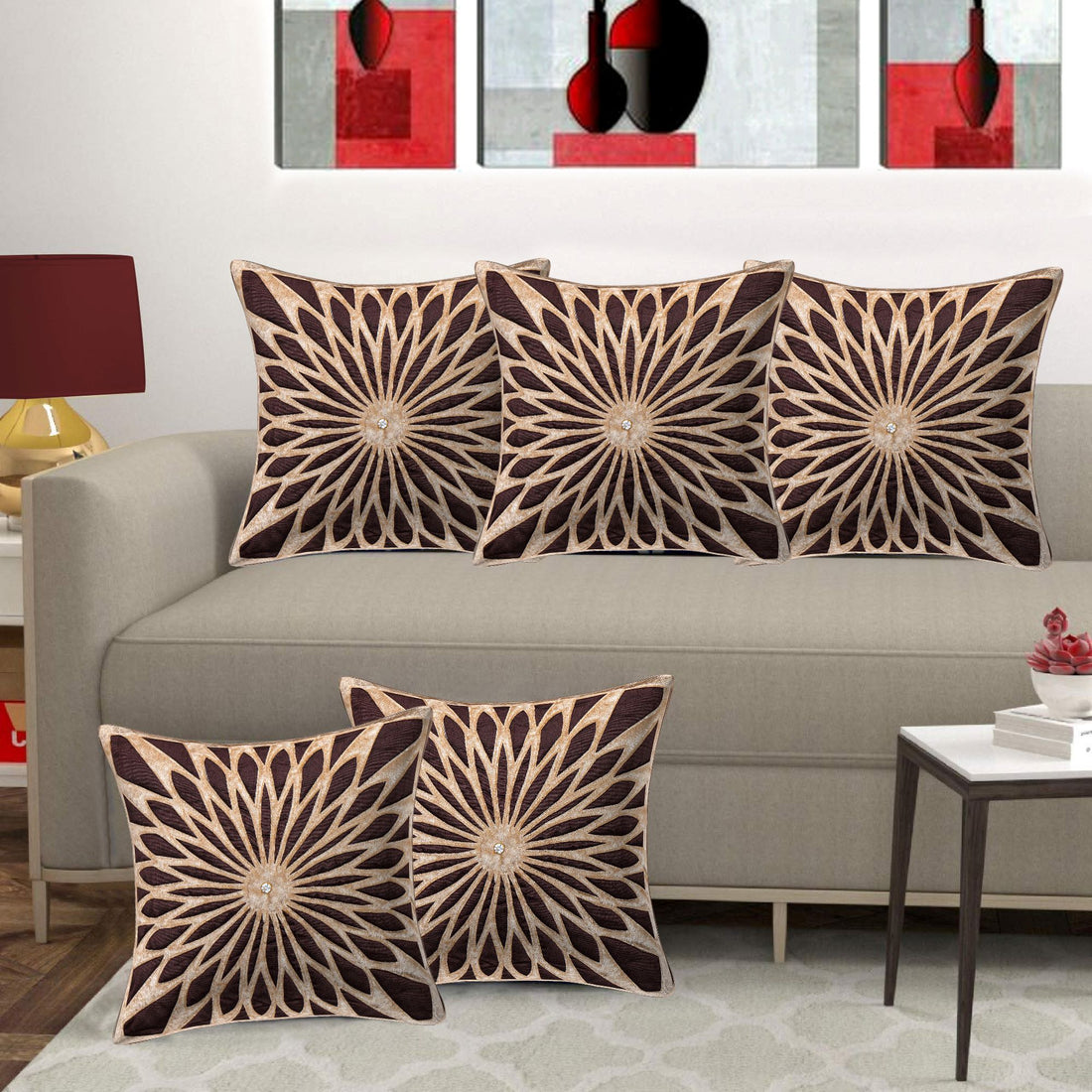 Decorative pillows with sunburst pattern on a gray sofa in a living room setting.