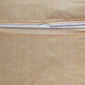 Close-up of a beige fabric with a silver zipper running horizontally.