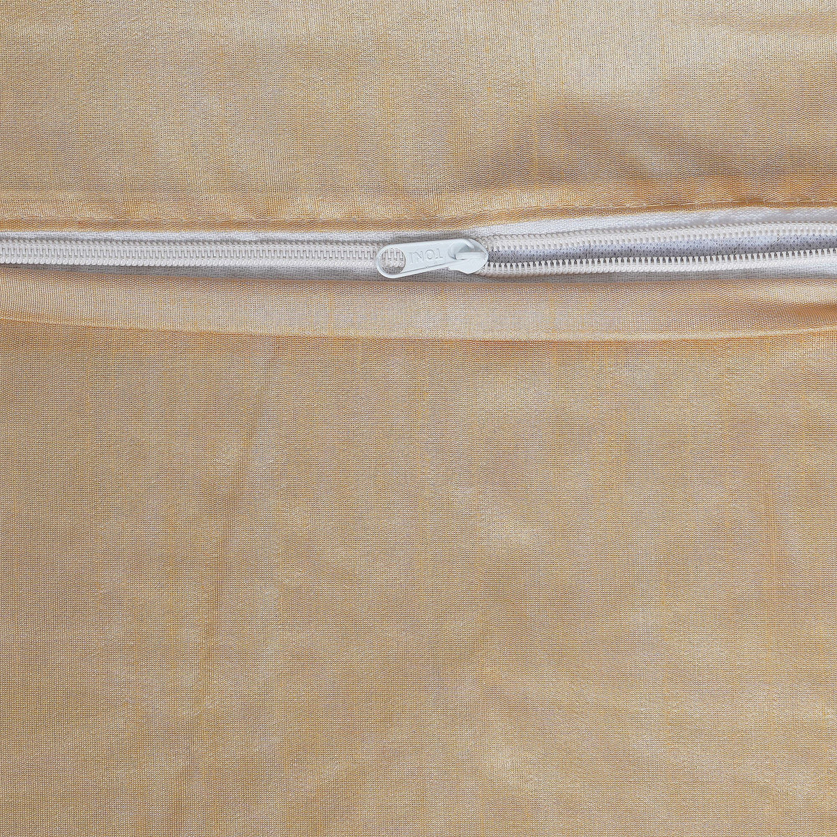 Close-up of a beige fabric with a silver zipper running horizontally.