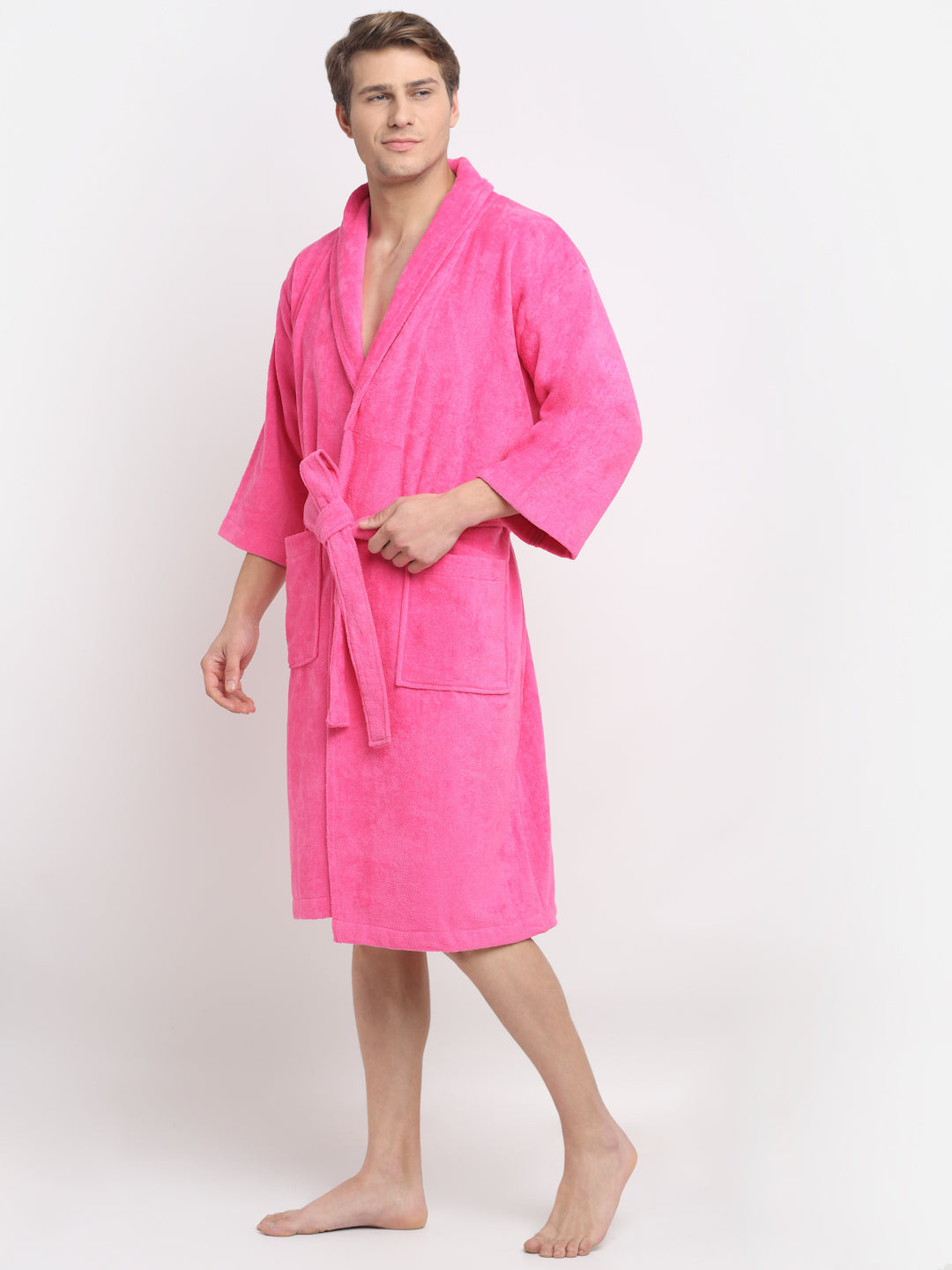 A person wearing a fushchia unisex cotton bathrobe, smiling.