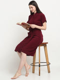 A woman sitting on a stool and wearing a white micro terry bathrobe and holding a book