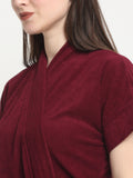 Close-up of a woman wearing a grape wine micro terry bathrobe with a tie belt