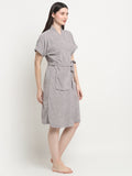 A Woman wearing a grey micro terry bathrobe with a tie belt