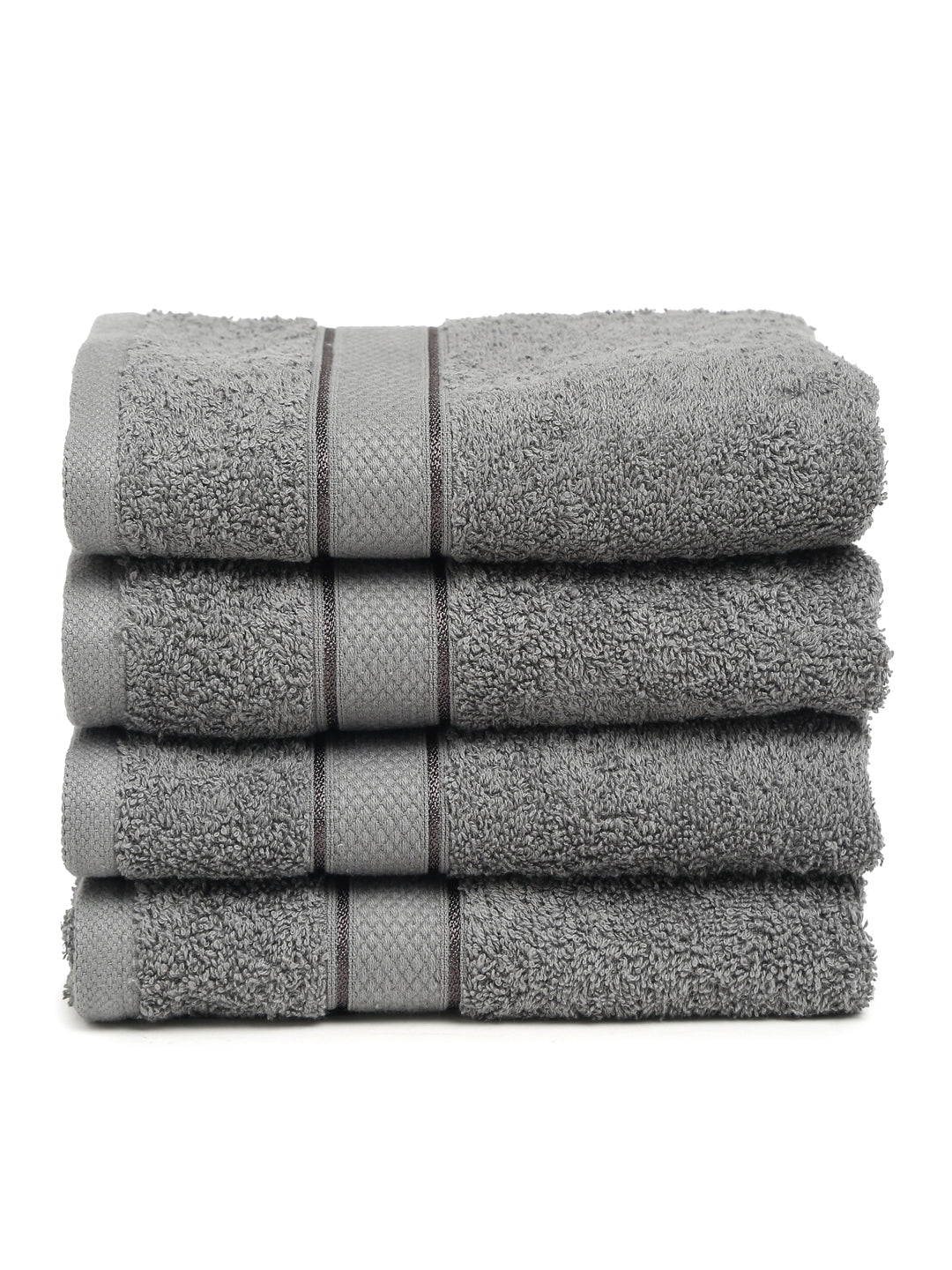 A set of grey Creeva brand hand towels stacked on a bathroom counter, with a wooden backdrop and a white bowl in the foreground.