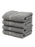 A set of grey Creeva brand hand towels stacked on a bathroom counter, with a wooden backdrop and a white background.