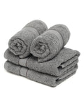 A set of grey Creeva brand hand towels stacked on a bathroom counter, with a wooden backdrop and a white background.