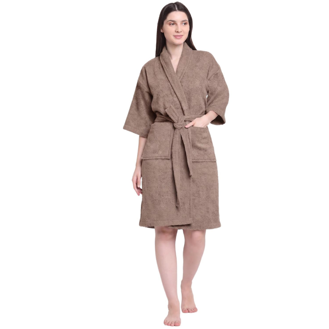 A woman modeling a brown bathrobe with a tie belt and front pockets, standing against a plain white background.