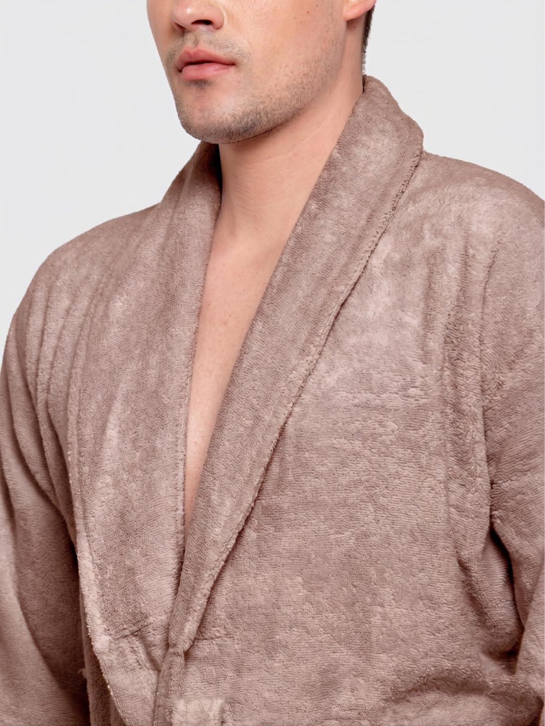 A man modeling a short-sleeved brown terry cloth bathrobe against a plain white background.
