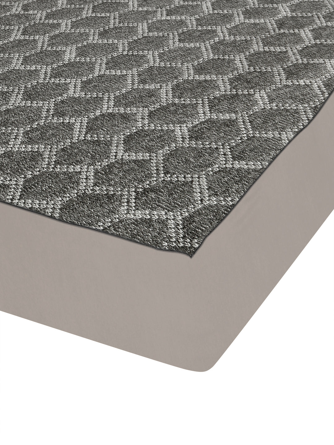 A close-up of a gray and white geometric patterned rug with a solid taupe-beige underside, shown on a white background.