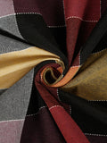 A close-up of a draped plaid fabric with a spiral twist, showing stripes of black, deep red, mustard yellow, gray, and white dashed lines.