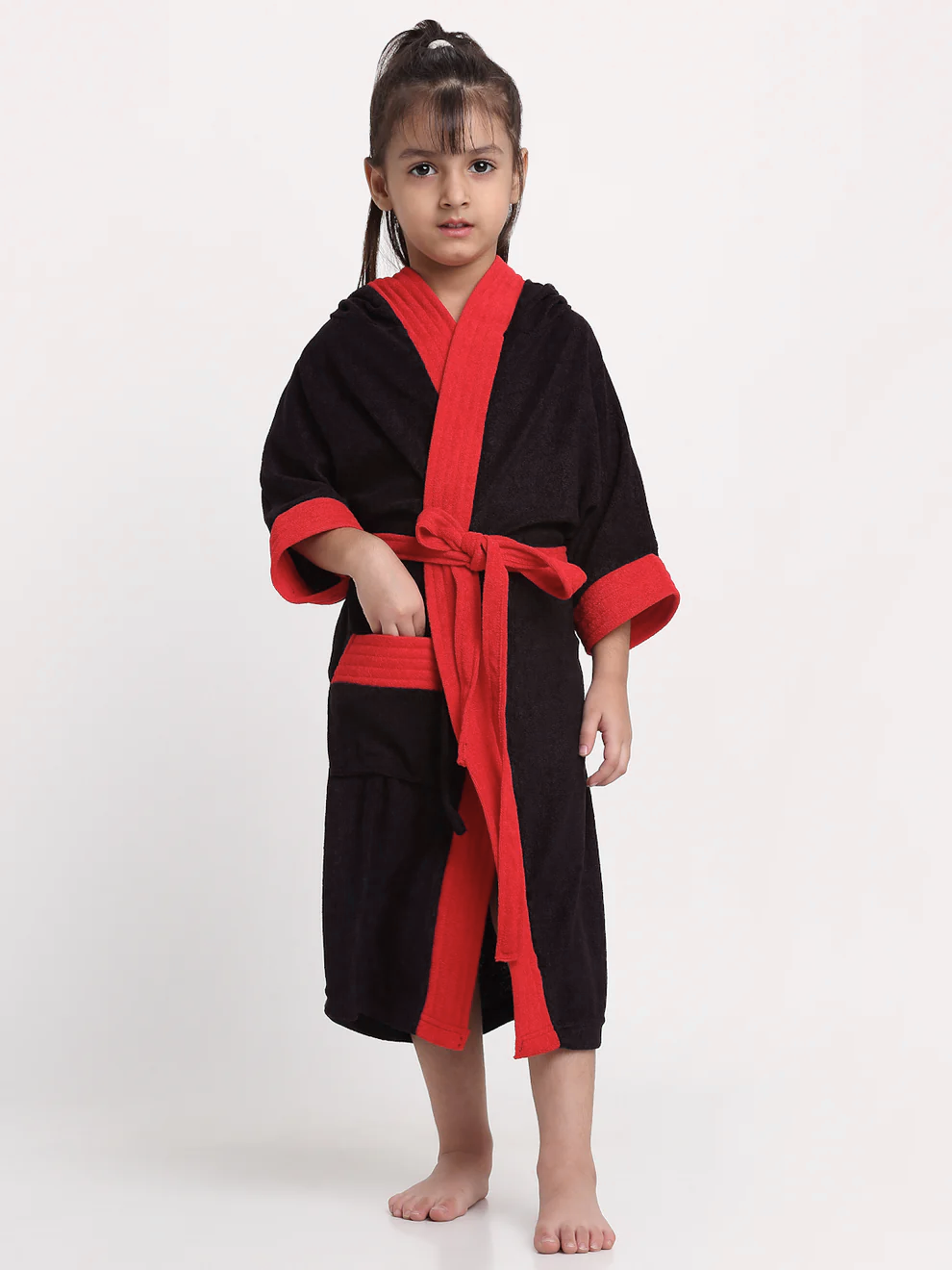 Child wearing a black and red robe on a white background