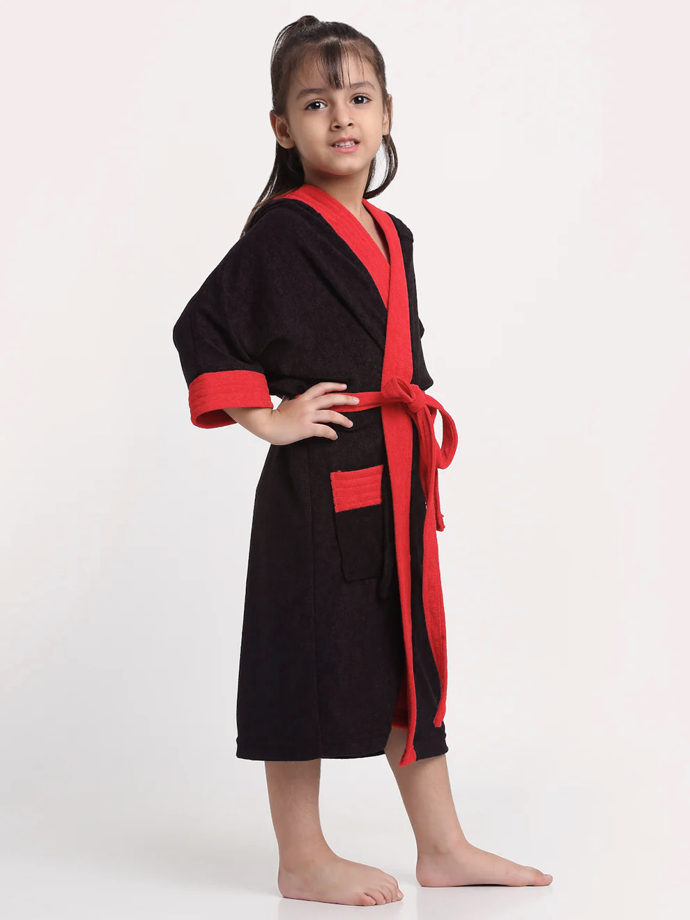 Child wearing a black and red robe on a white background