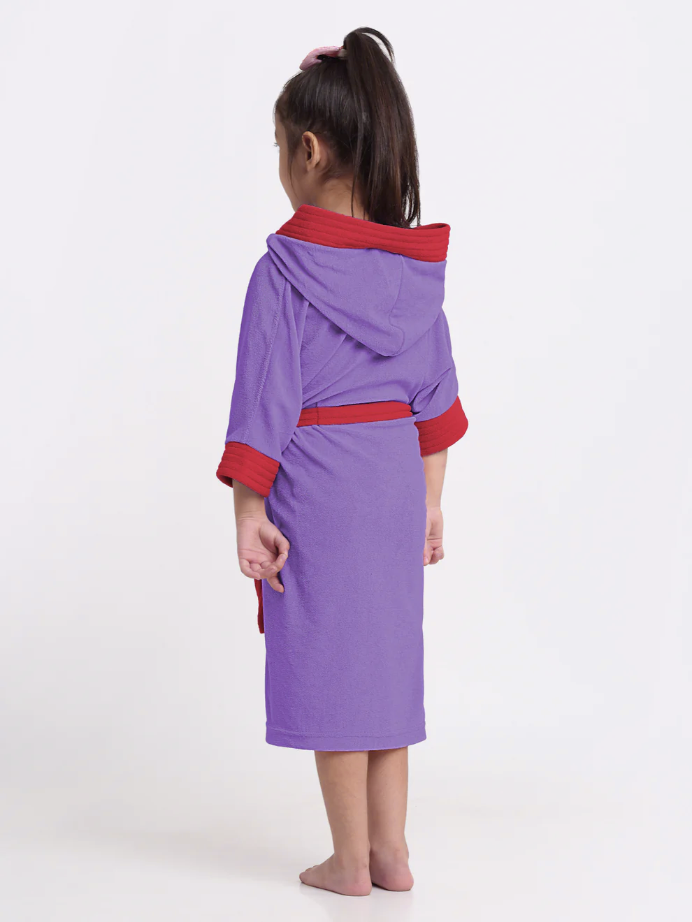 Child wearing a purple and red robe on a white background