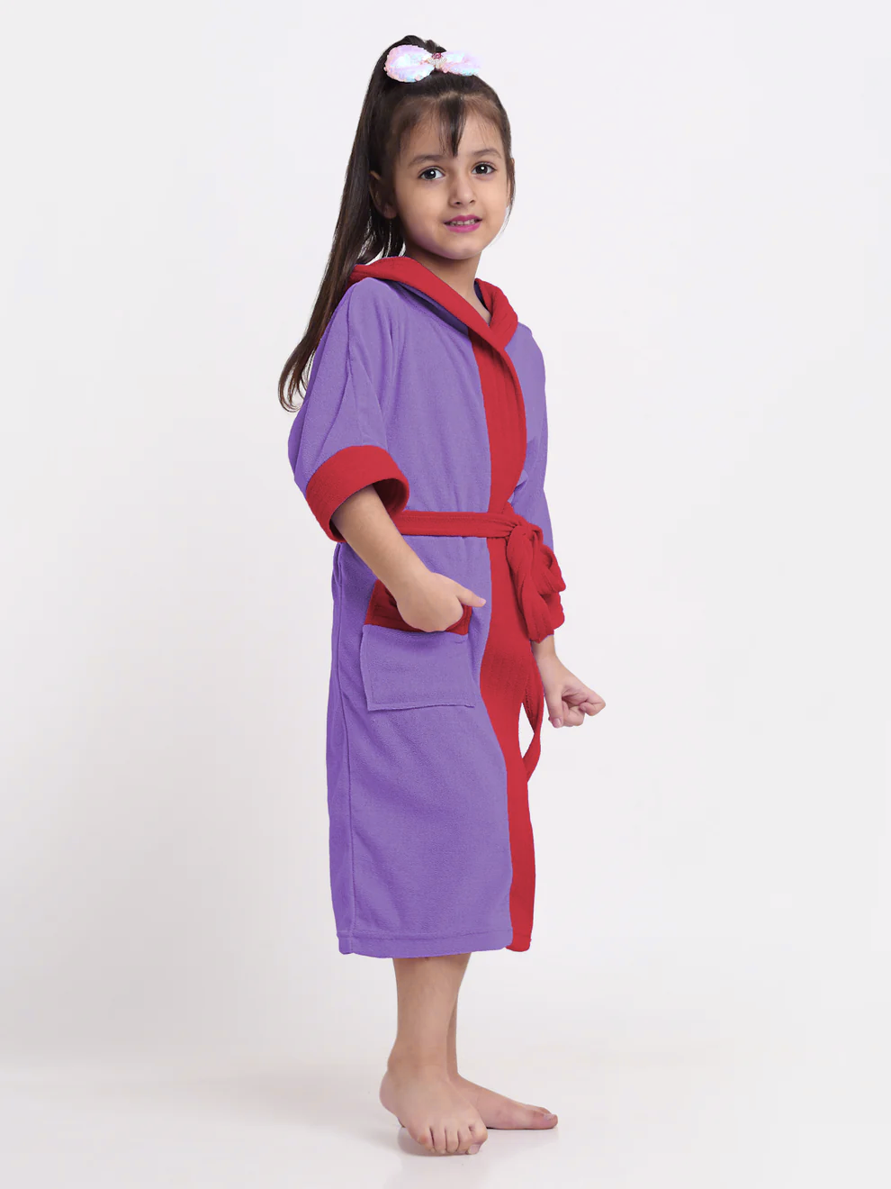 Child wearing a purple and red robe on a white background