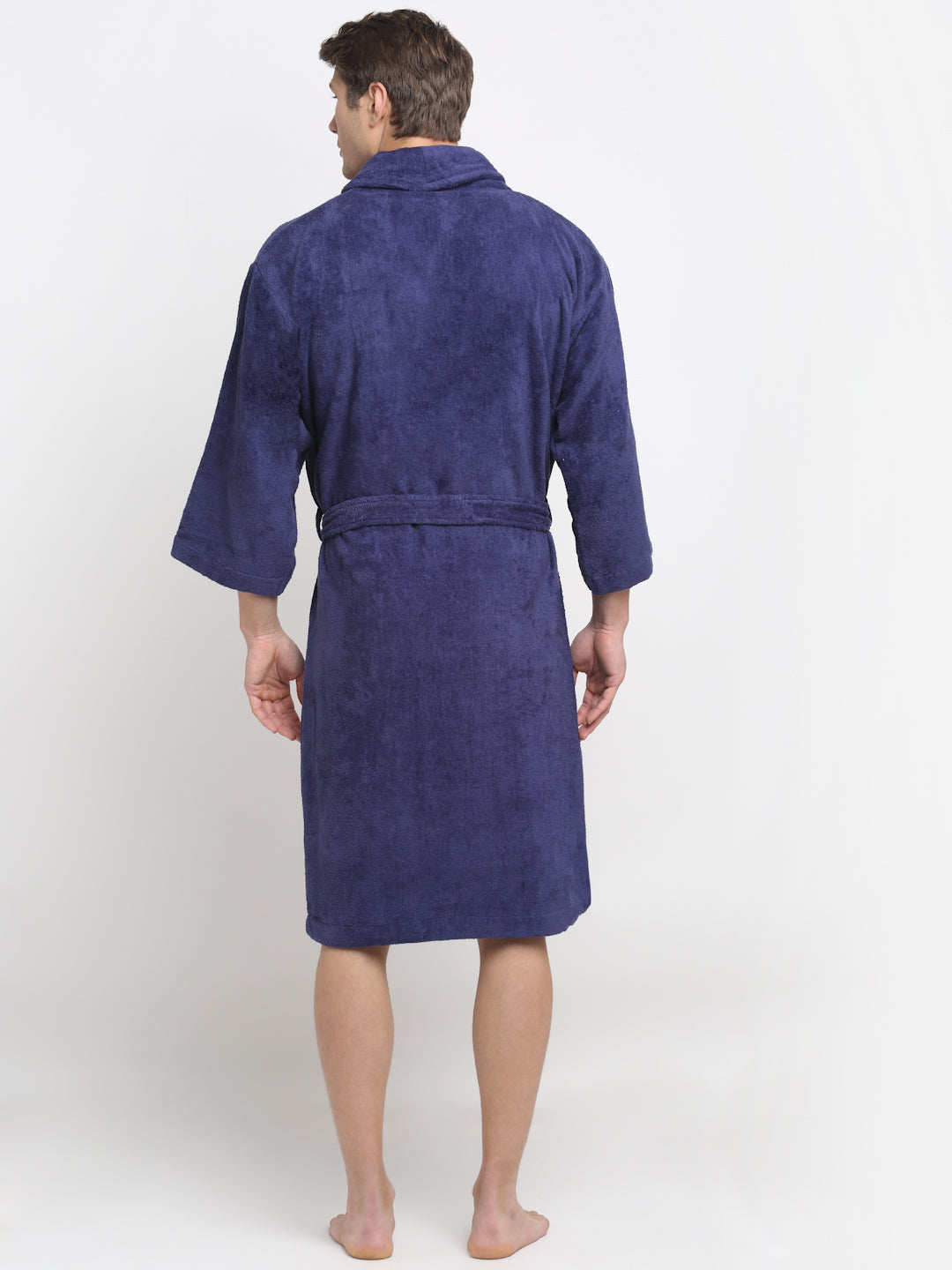 Back view of a man wearing a navy blue cotton bathrobe with a tie belt