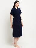 A Woman wearing a navy blue micro terry bathrobe with a tie belt