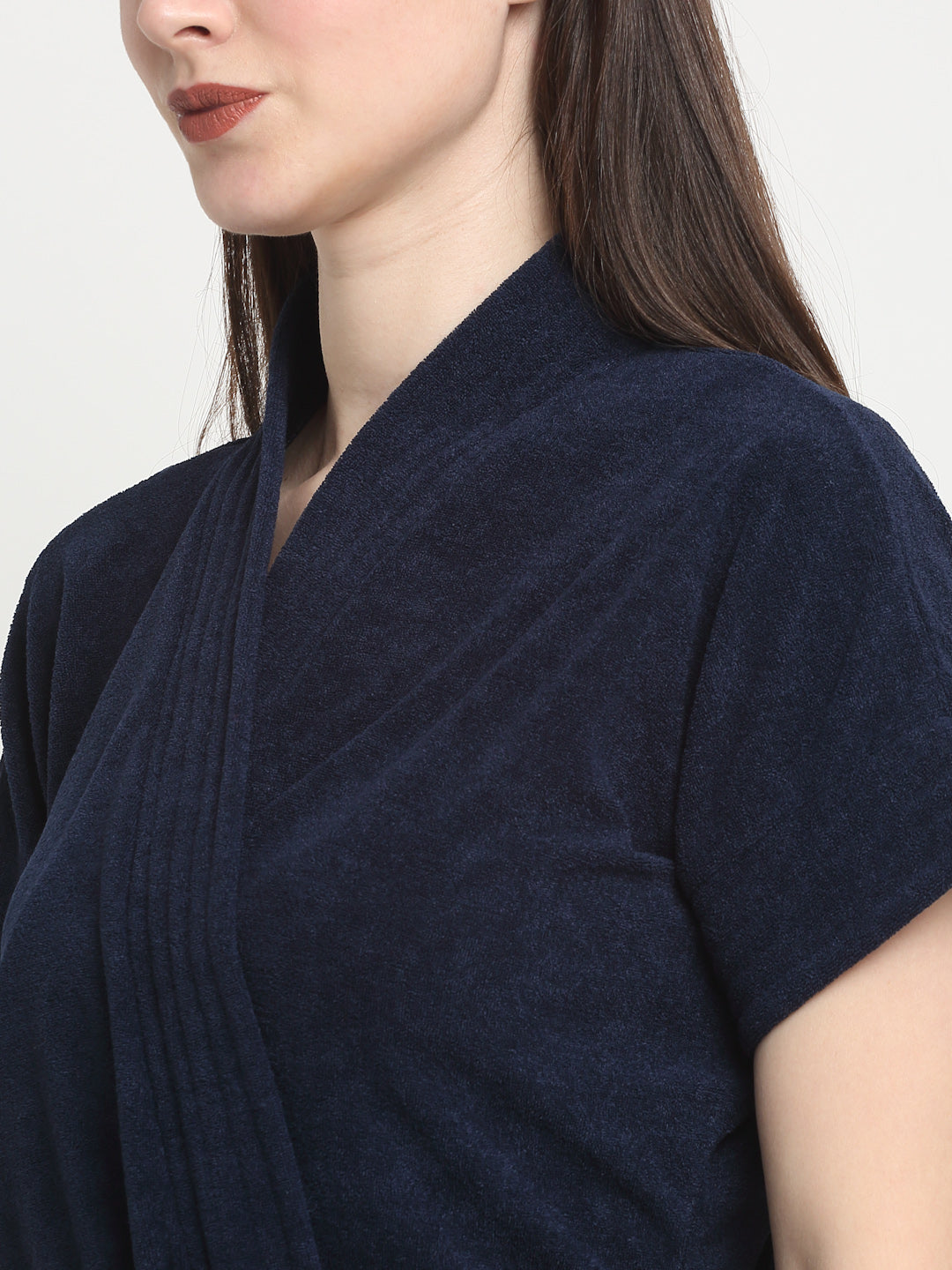 Close-up of a woman wearing a navy-blue micro terry bathrobe with a tie belt