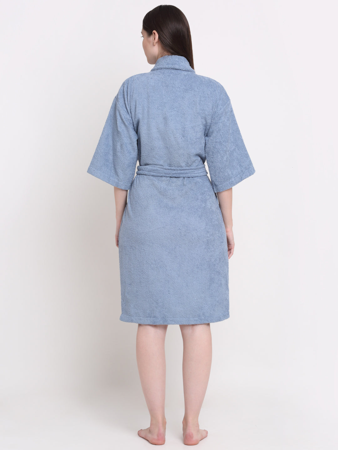Back view of a woman wearing an ocean blue bathrobe with a waist belt