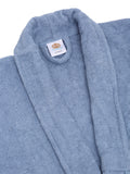Close-up of a ocean blue cotton bathrobe showing the shawl collar, soft terry texture, and CREEVA label