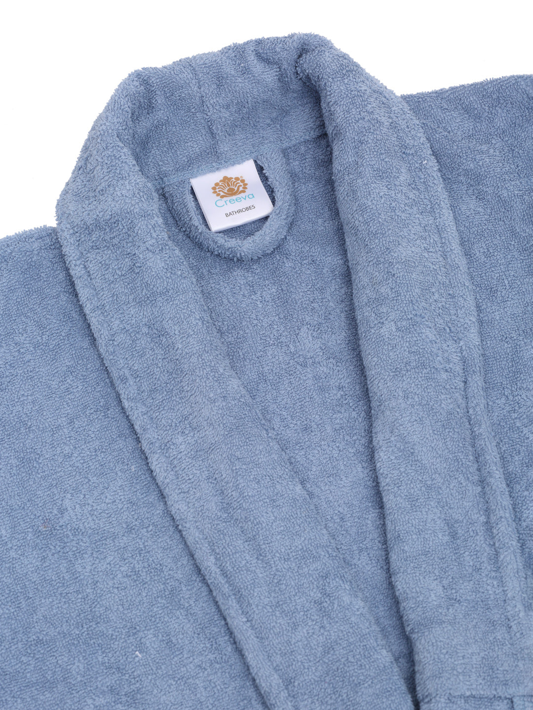 Close-up of a ocean blue cotton bathrobe showing the shawl collar, soft terry texture, and CREEVA label