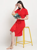 A woman sitting on a stool and wearing a red micro terry bathrobe and holding a book
